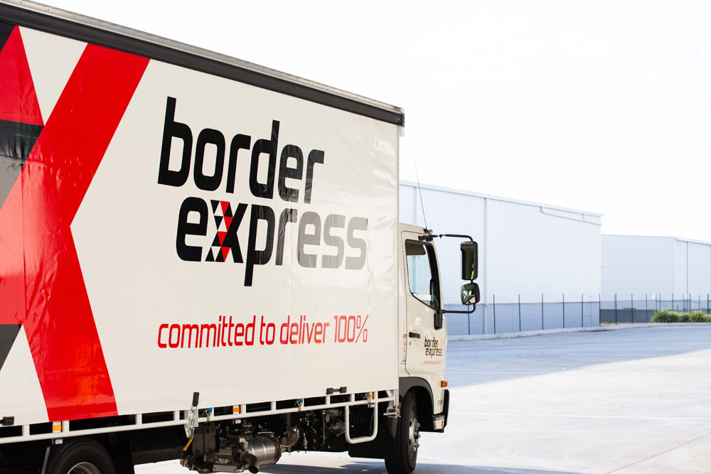 A "Border Express" truck parked with warehouses in background