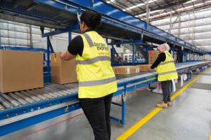 Two Border Express' warehouse operatives sort packages on conveyor belts Two Border Express' warehouse operatives sort packages on conveyor belts