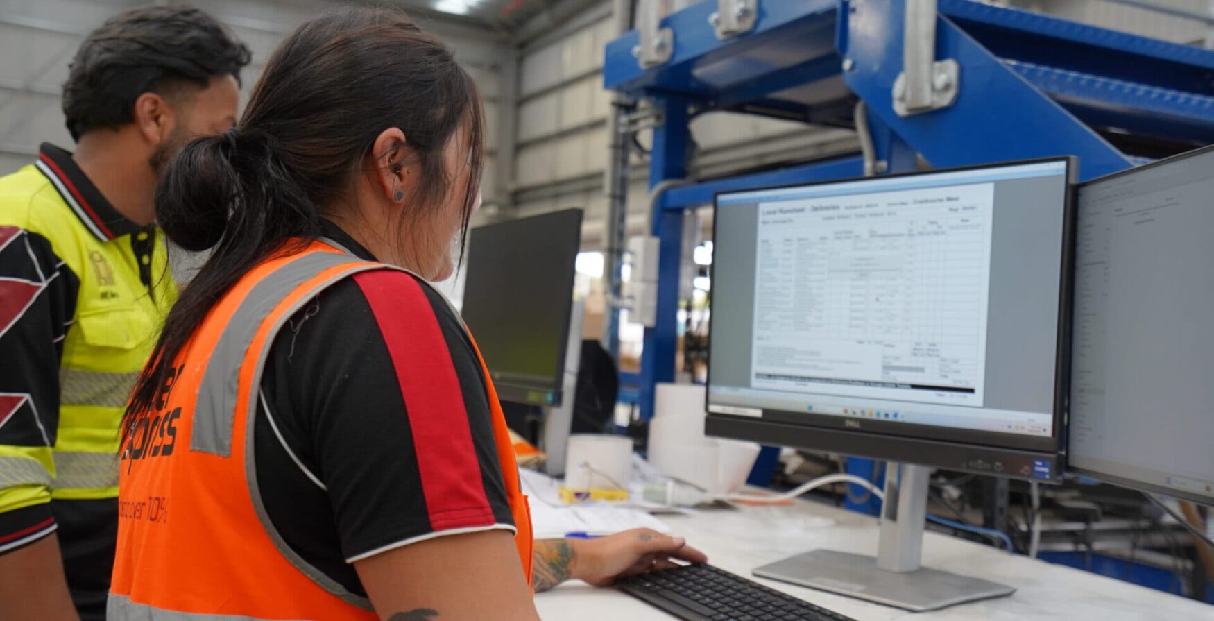 Two warehouse workers review logistics on a computer screen scaled aspect ratio 344 176 scaled